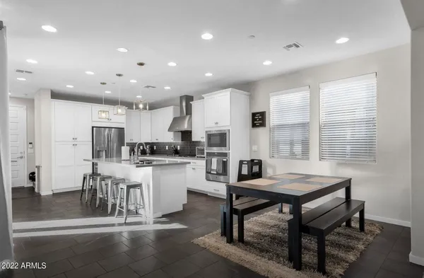 a kitchen with a dining table chairs stove refrigerator and cabinets