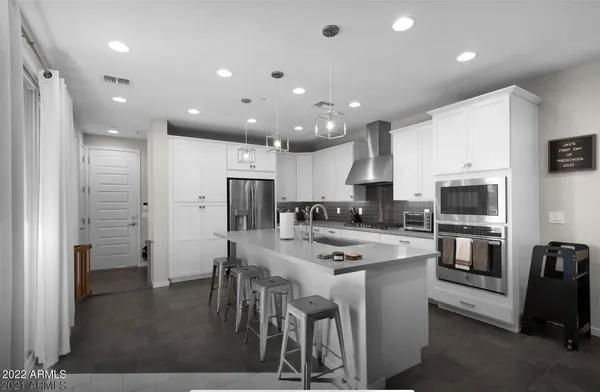 a kitchen with a refrigerator and a stove top oven