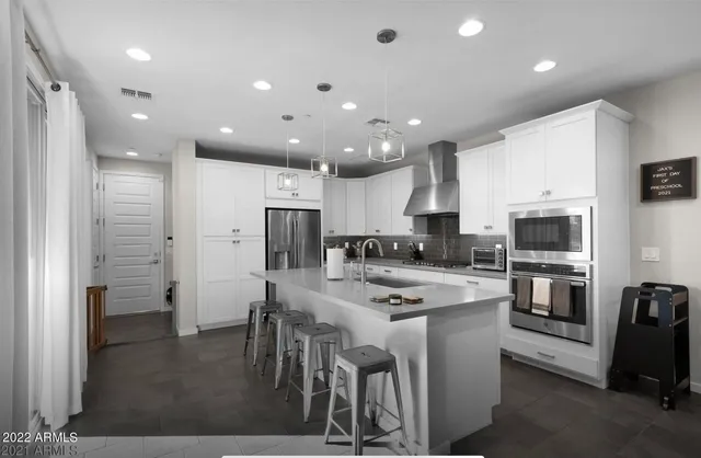 a kitchen with a refrigerator and a stove top oven