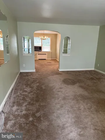 a view of a big room with windows and chandelier