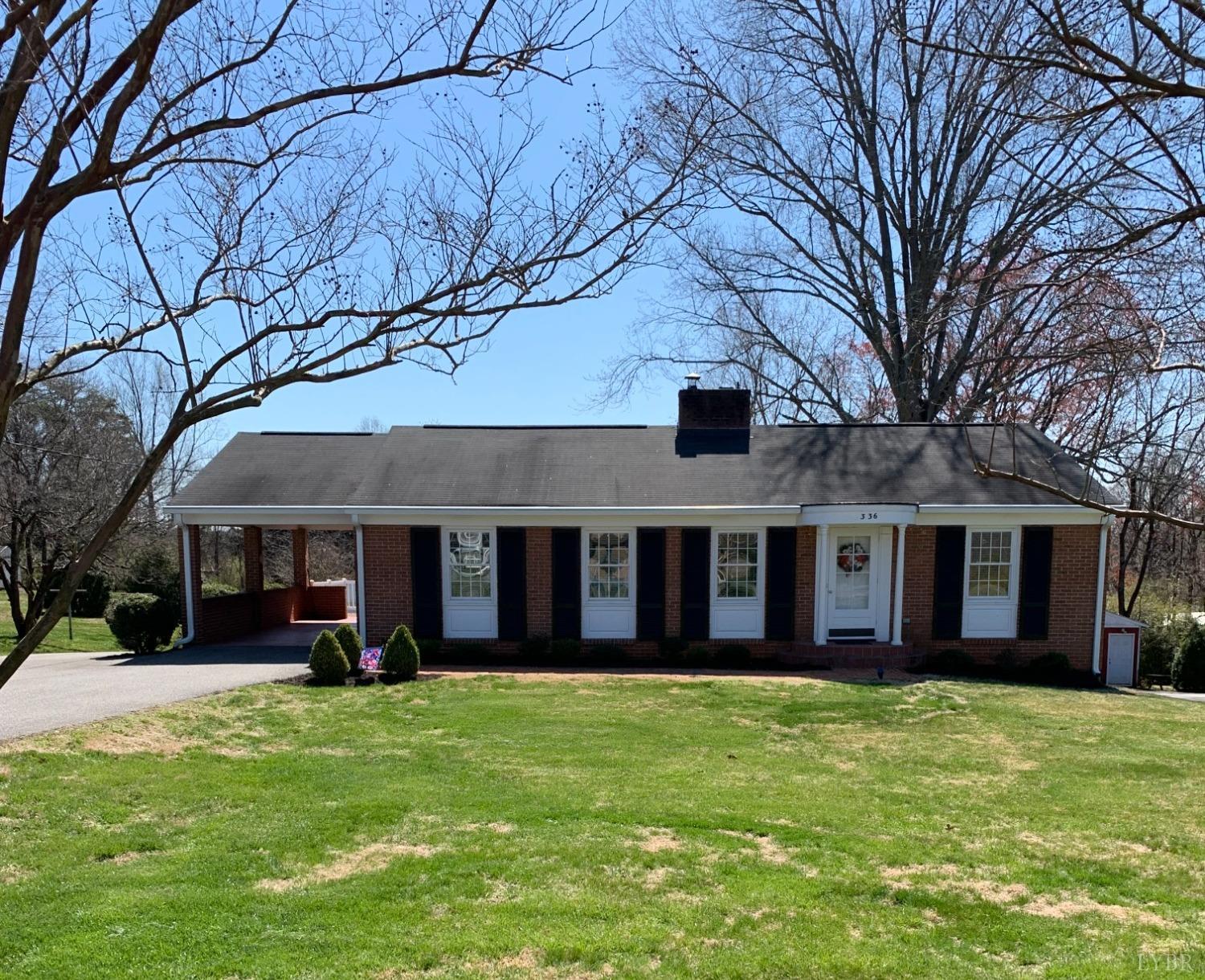 a view of a house with a yard and large tree
