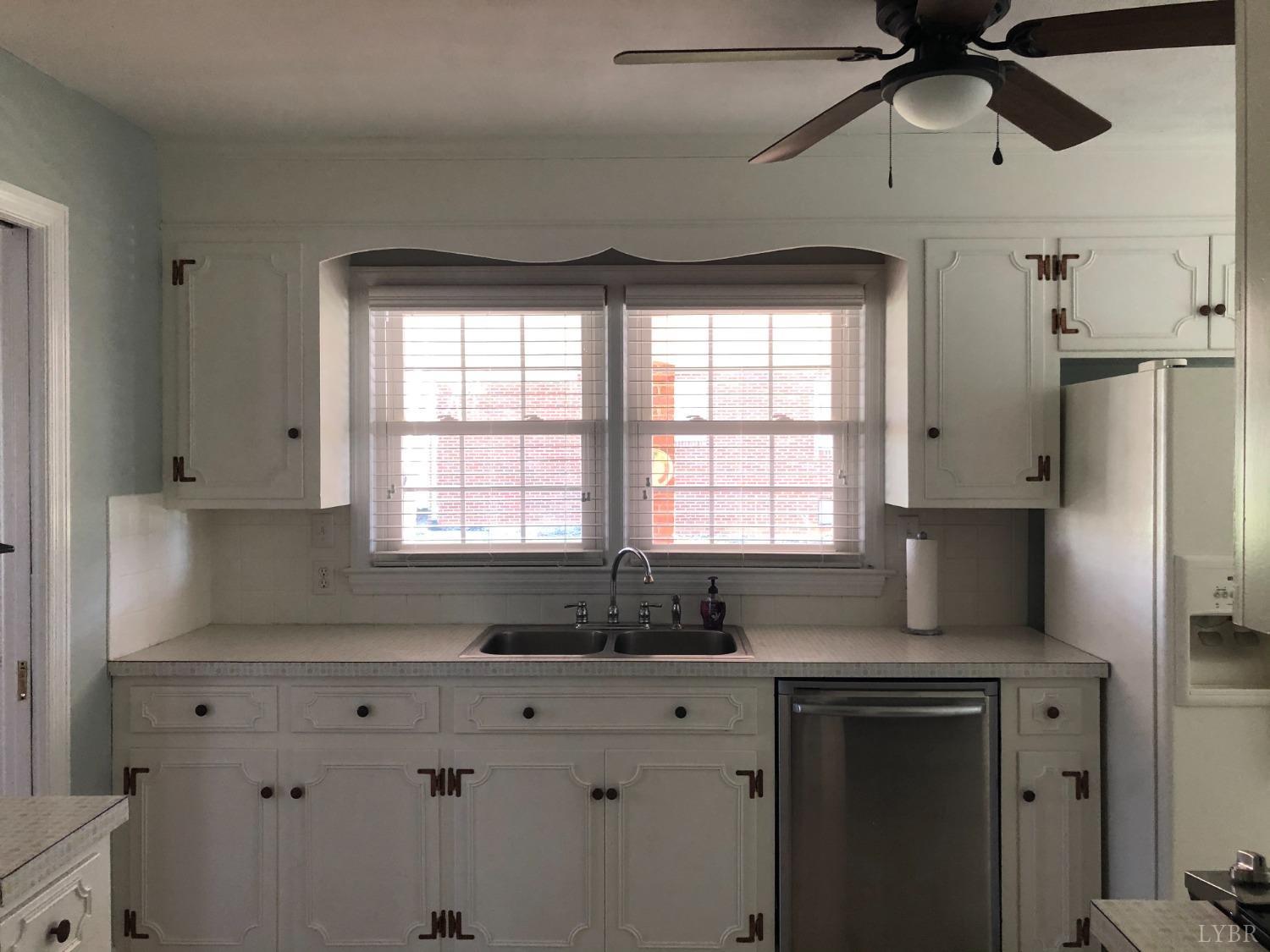 336 North Main Street Amherst, VA 24521 - Photo 12 of 60 a kitchen with stainless steel appliances kitchen island a large window cabinets a sink and a counter top space
