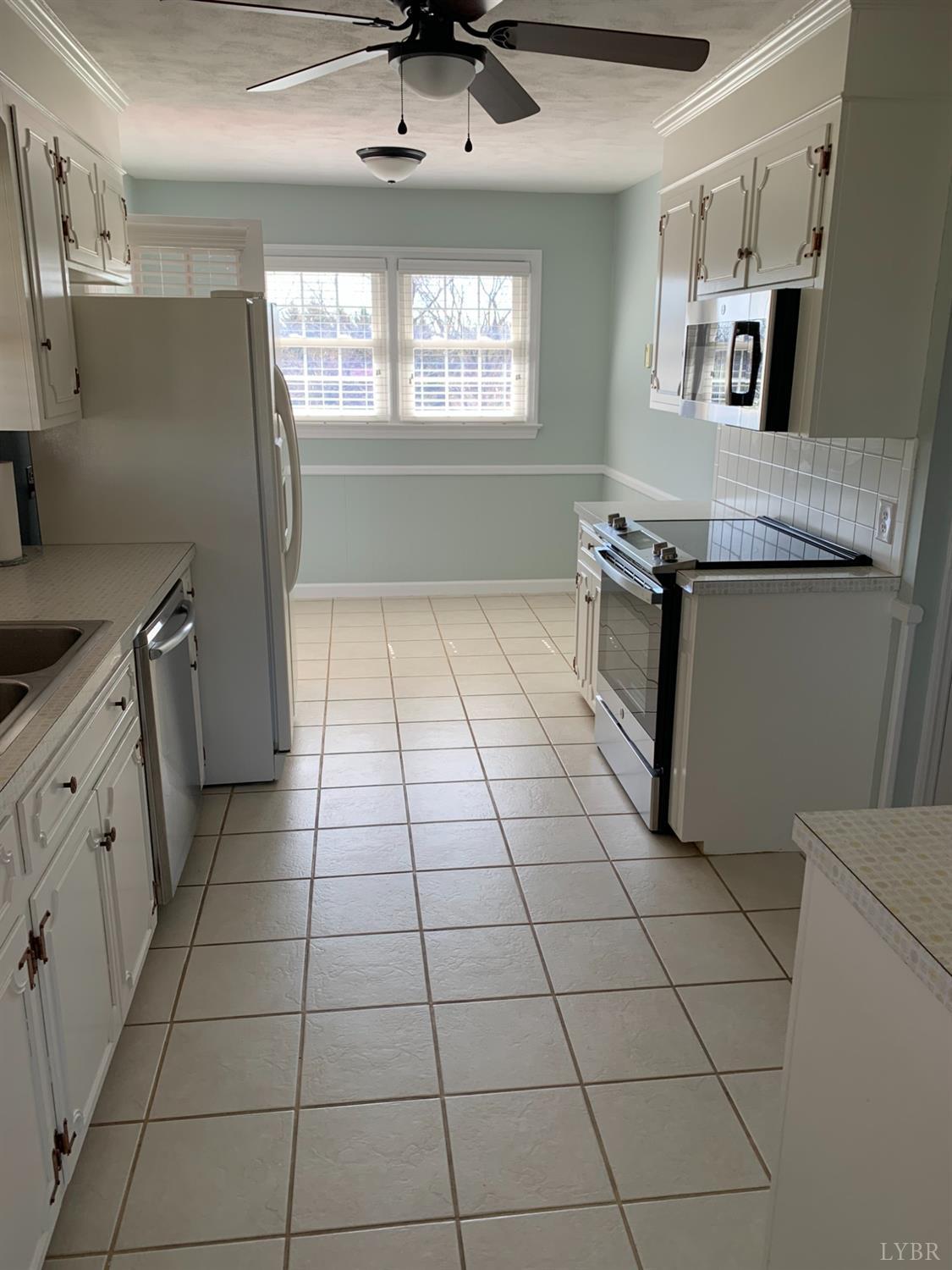 336 North Main Street Amherst, VA 24521 - Photo 13 of 60 a kitchen with granite countertop a stove a sink and a refrigerator