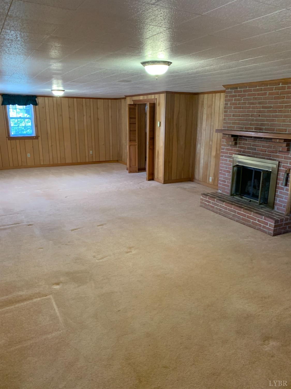 336 North Main Street Amherst, VA 24521 - Photo 47 of 60 an empty room with a fireplace and chandelier fan