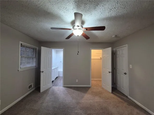 a view of an empty room and chandelier fan