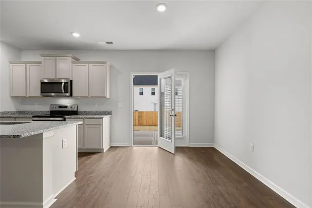 a kitchen with a refrigerator a stove top oven a sink and dishwasher with wooden floor