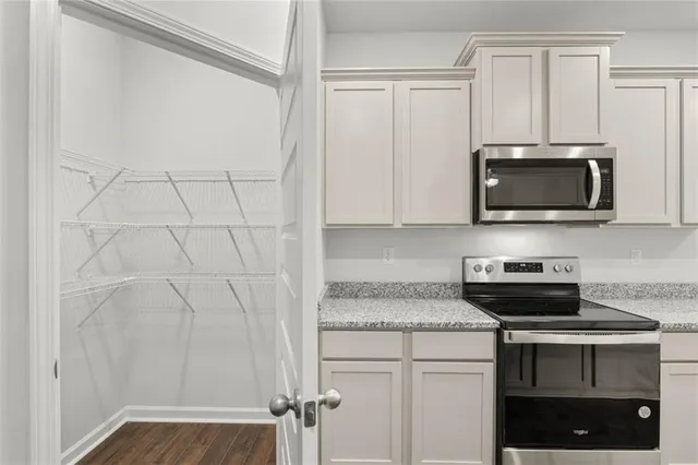 a kitchen with stainless steel appliances white cabinets and a stove top oven