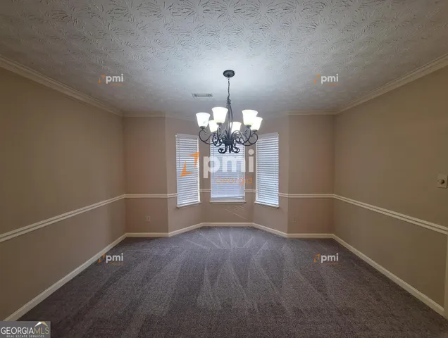 a view of a room with wooden floor and chandelier