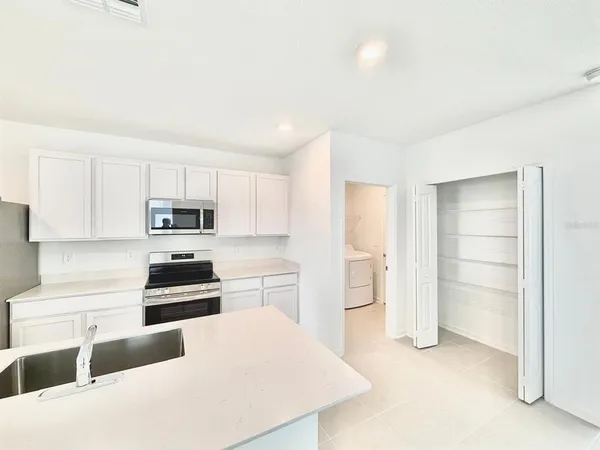 a kitchen with stainless steel appliances a refrigerator and a stove top oven
