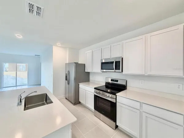 a kitchen with stainless steel appliances granite countertop a refrigerator and a stove top oven