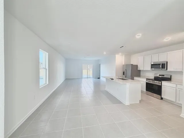 a large white kitchen with cabinets