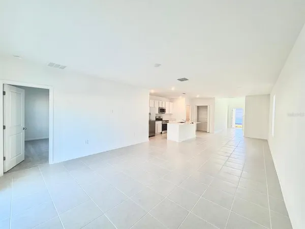 a view of empty room with kitchen
