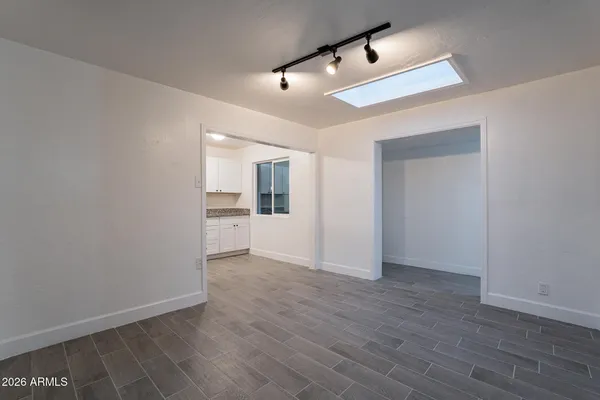 an empty room with wooden floor ceiling fan and windows