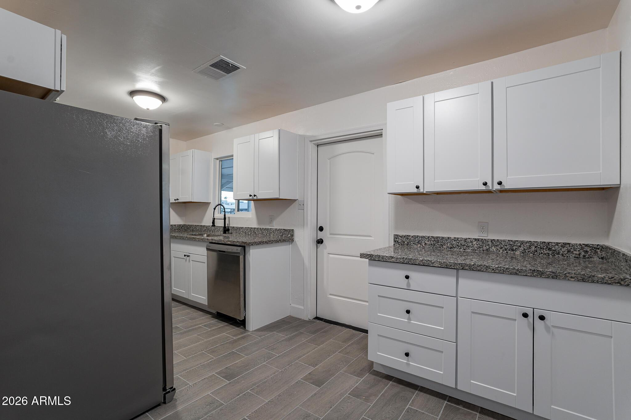 536 West 18th Street Tempe, AZ 85281 - Photo 21 of 39 a kitchen with granite countertop white cabinets and stainless steel appliances