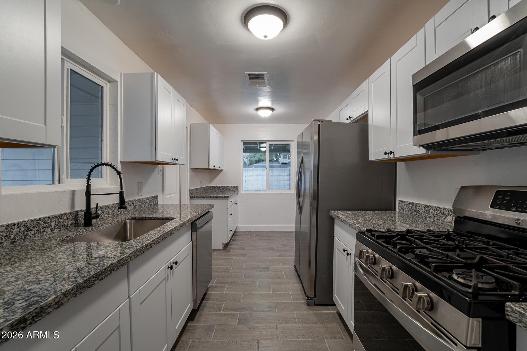 536 West 18th Street Tempe, AZ 85281 - Photo 22 of 39 a kitchen with granite countertop a sink stove and refrigerator