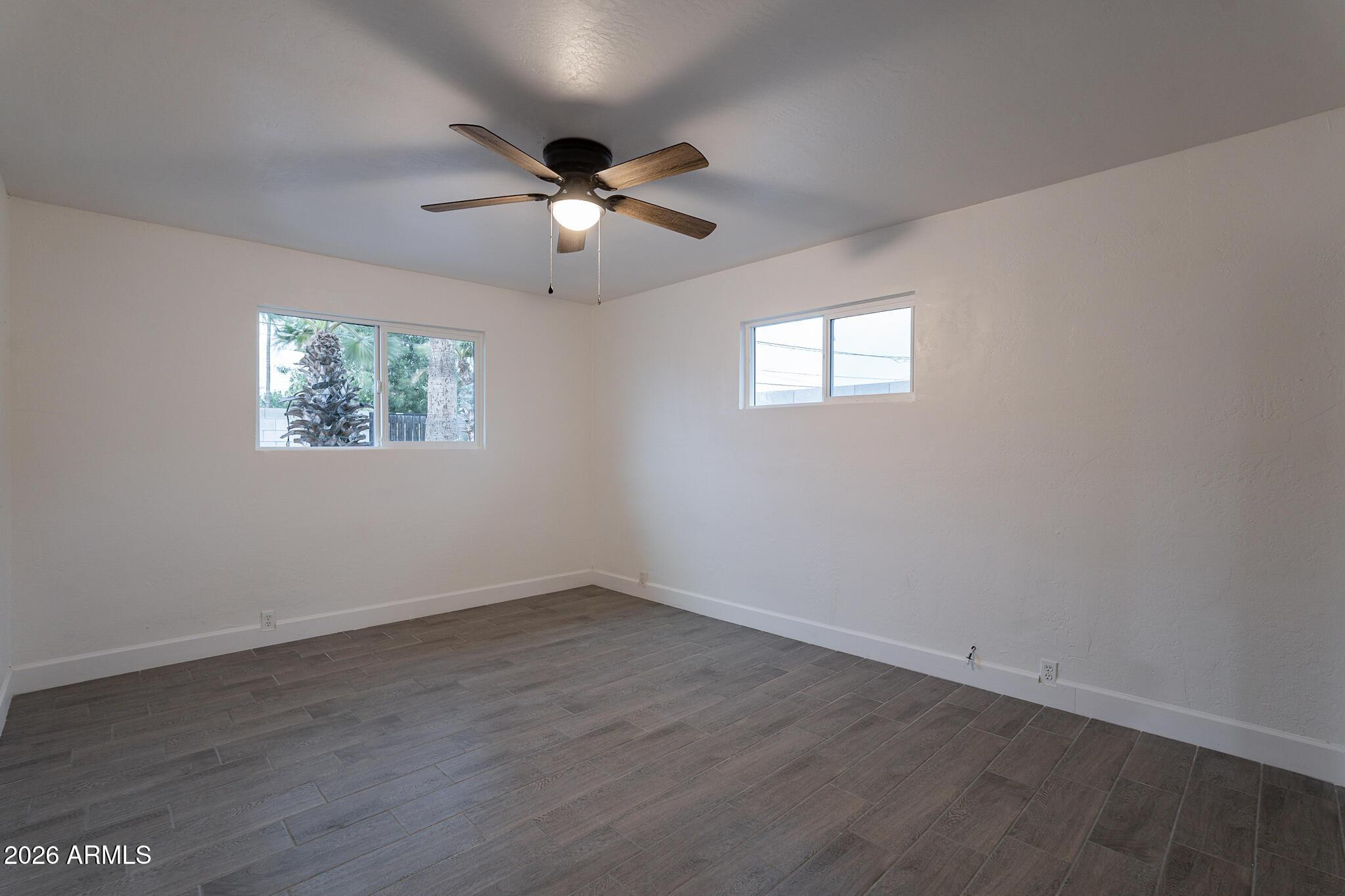 536 West 18th Street Tempe, AZ 85281 - Photo 36 of 39 an empty room with wooden floor ceiling fan and window