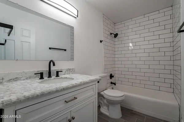 an empty room with wooden floor ceiling fan and windows