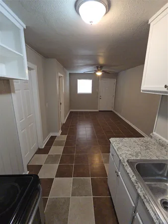 a kitchen with a sink a stove and cabinets