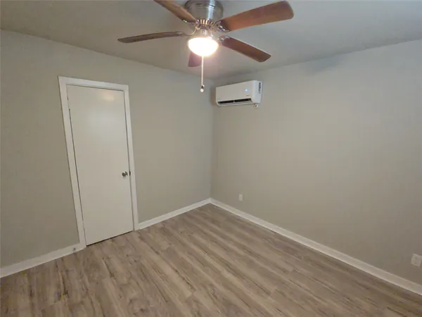 an empty room with a fan & a ceiling fan