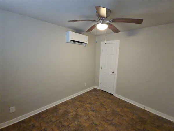 an empty room with a ceiling fan and a window