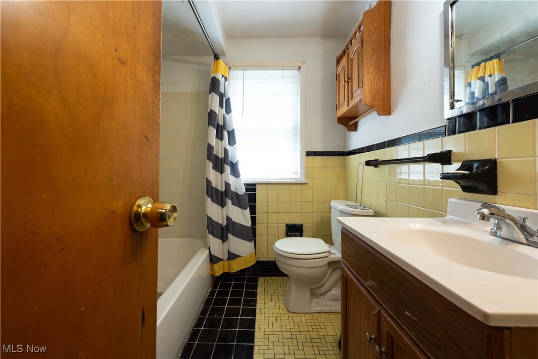 665 Babbitt Road Euclid, OH 44123 - Photo 12 of 17 Full bath featuring toilet, a wainscoted wall, tile walls, tile patterned flooring, and vanity