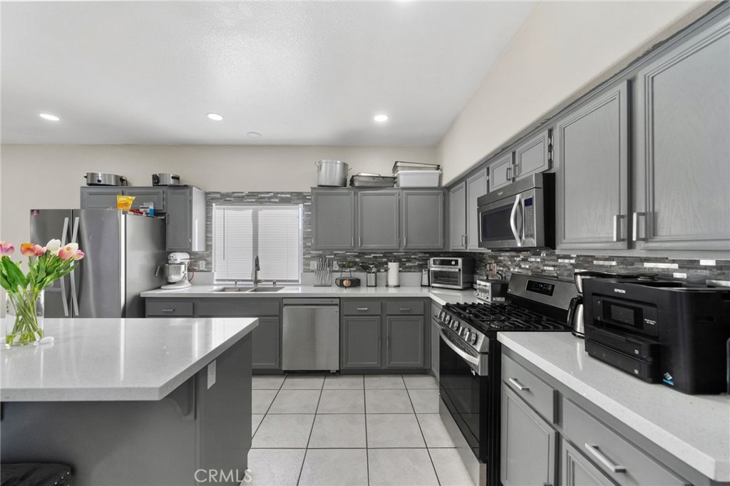 1494 Rabbit Peak Way Hemet, CA 92545 - Photo 13 of 45 a kitchen with a sink stove and cabinets