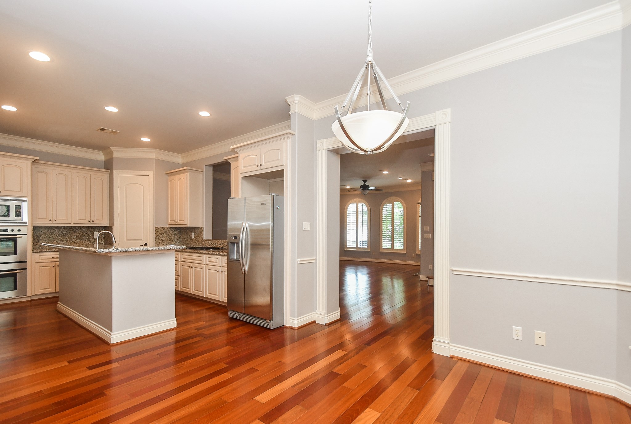 717 Welch Street Houston, TX 77006 - Photo 11 of 32 a kitchen with stainless steel appliances granite countertop a refrigerator a stove and white cabinets with wooden floors