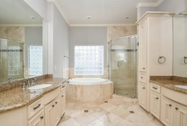 a bathroom with a granite countertop tub sink and mirror