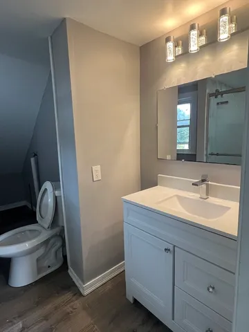a bathroom with a toilet sink and mirror