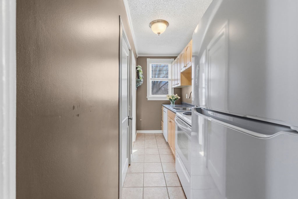 138 South Main Street, Unit 13 Fairhaven, MA 02719 - Photo 6 of 31 a view of a kitchen with a refrigerator