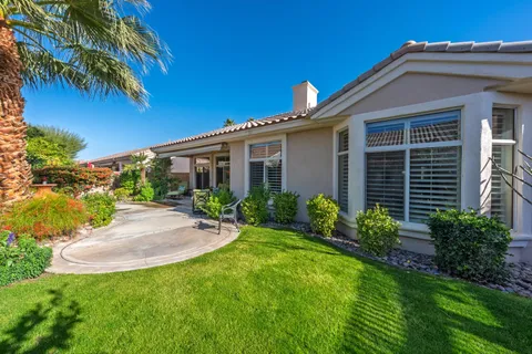 a front view of a house with a yard and potted plants