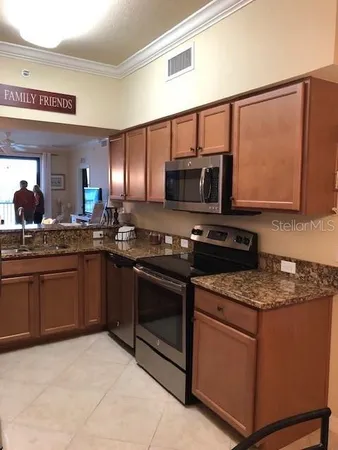 a kitchen with stainless steel appliances granite countertop a stove microwave and sink