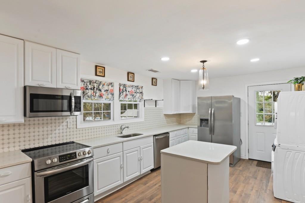a kitchen with stainless steel appliances a stove sink microwave and refrigerator