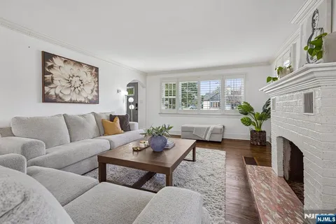 a living room with furniture a large window and a fireplace