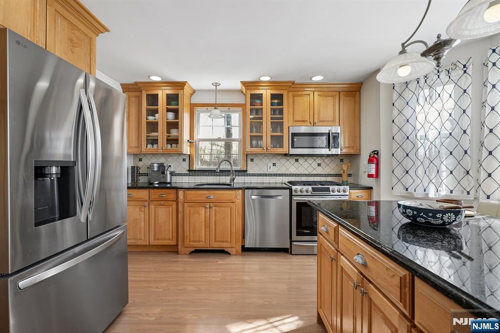 122 Johnson Avenue Mahwah, NJ 07430 - Photo 8 of 40 a kitchen with stainless steel appliances granite countertop a refrigerator a stove and a sink