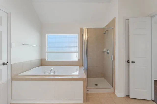 an empty room with wooden floor chandelier fan and windows