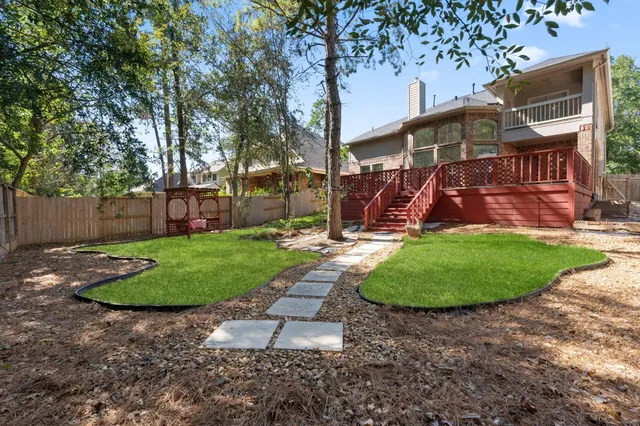a view of a backyard with wooden fence and a bench