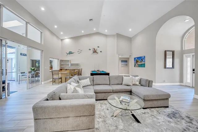 a room with furniture pool table wooden floor and windows
