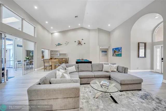 a room with furniture pool table wooden floor and windows