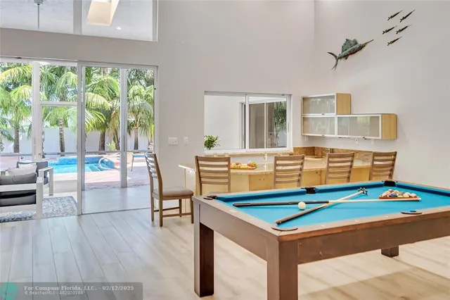 a kitchen with granite countertop white cabinets a sink a window and stainless steel appliances