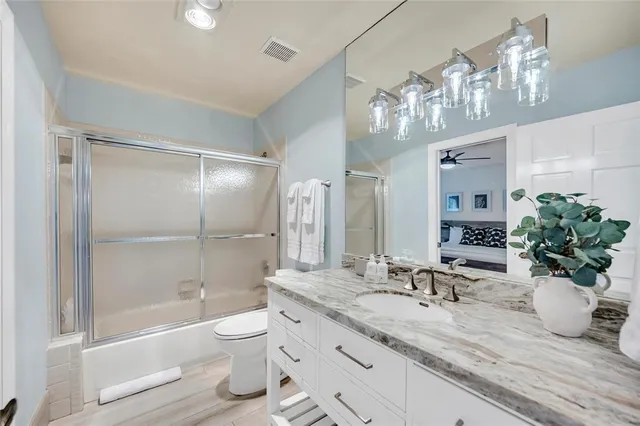 a spacious bedroom with a bed a couch and a potted plant