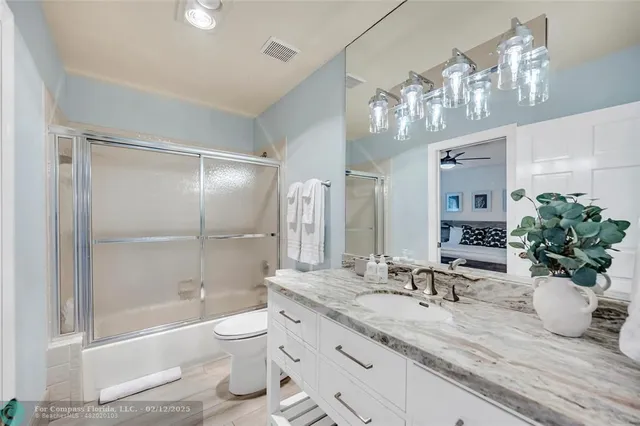 a spacious bedroom with a bed a couch and a potted plant