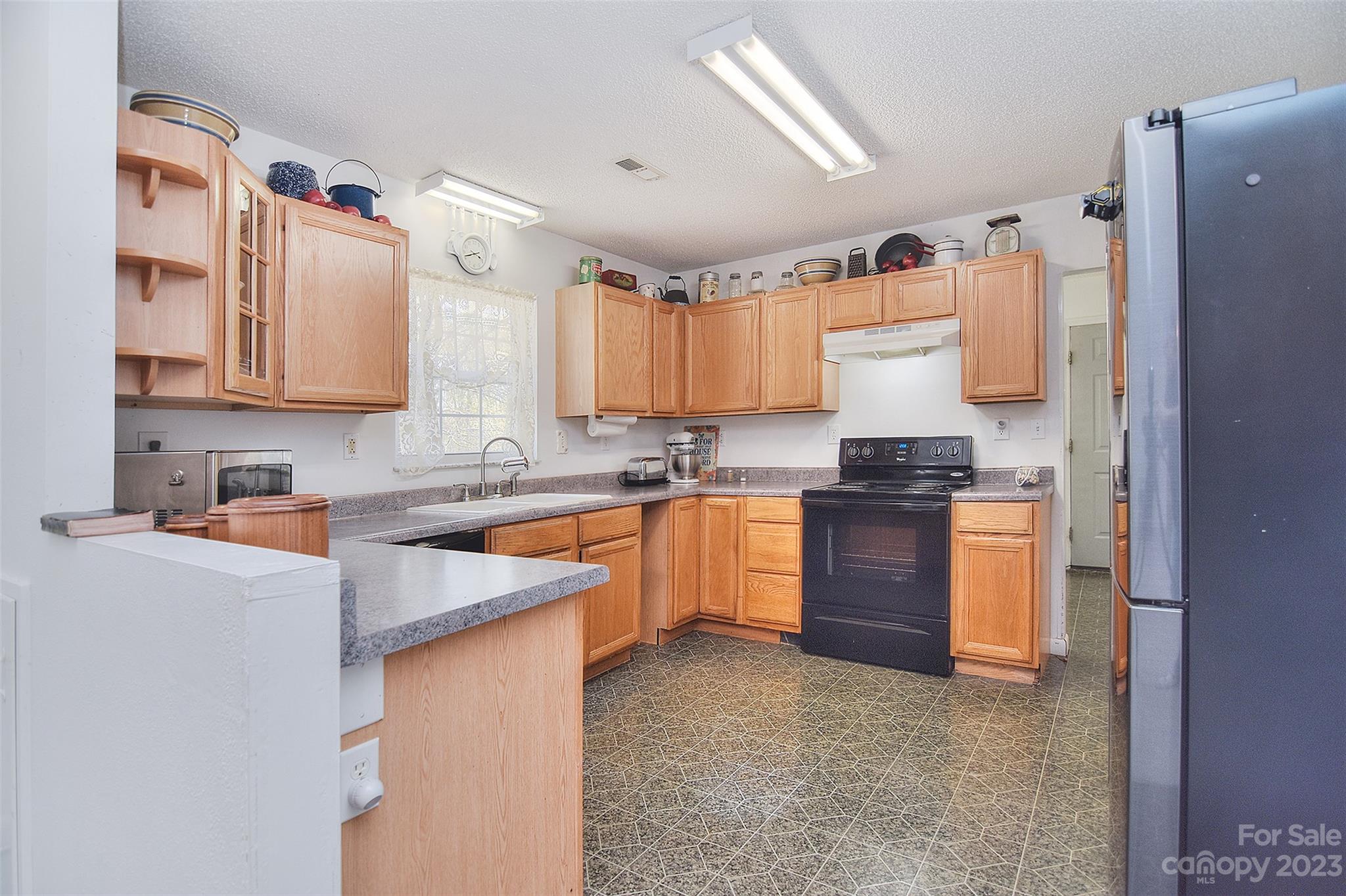 8705 Simpson Road Waxhaw, NC 28173 - Photo 13 of 46 a kitchen with granite countertop a sink stove and refrigerator