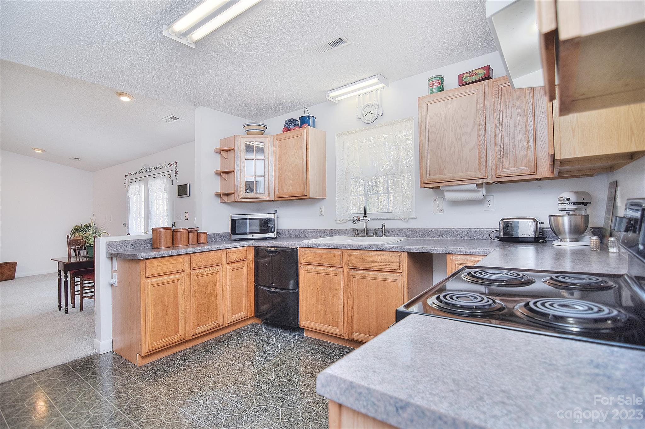 8705 Simpson Road Waxhaw, NC 28173 - Photo 14 of 46 a kitchen with stainless steel appliances granite countertop a sink stove and cabinets
