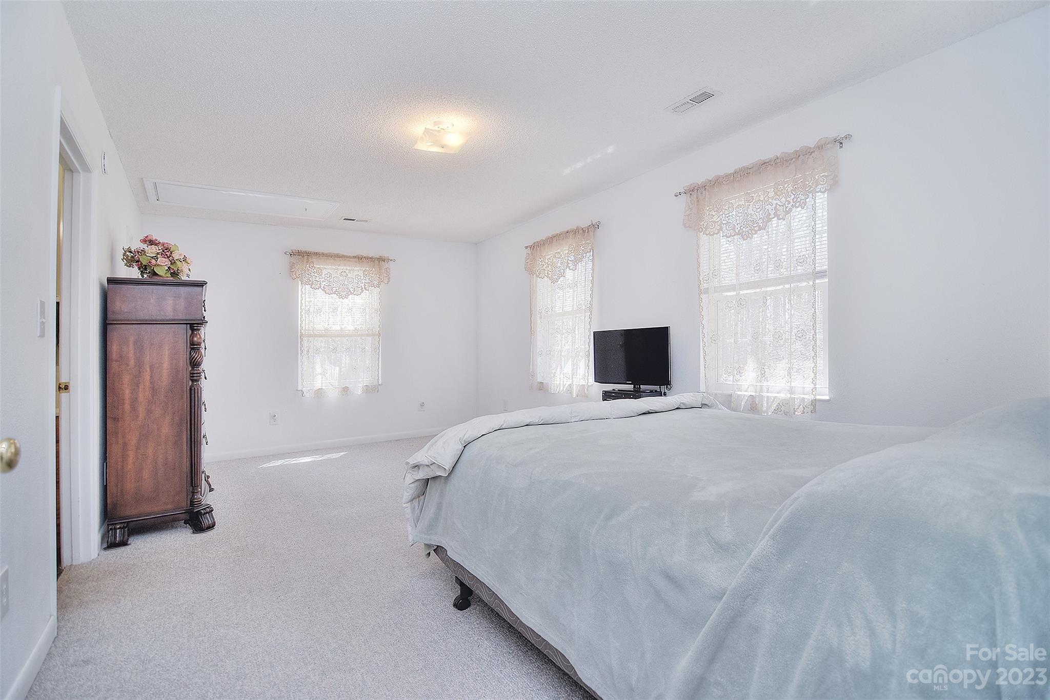 8705 Simpson Road Waxhaw, NC 28173 - Photo 19 of 46 a bedroom with a bed and a flat screen tv