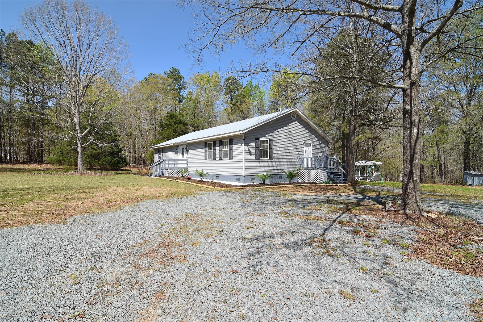 8705 Simpson Road Waxhaw, NC 28173 - Photo 2 of 46 a view of house with backyard and trees