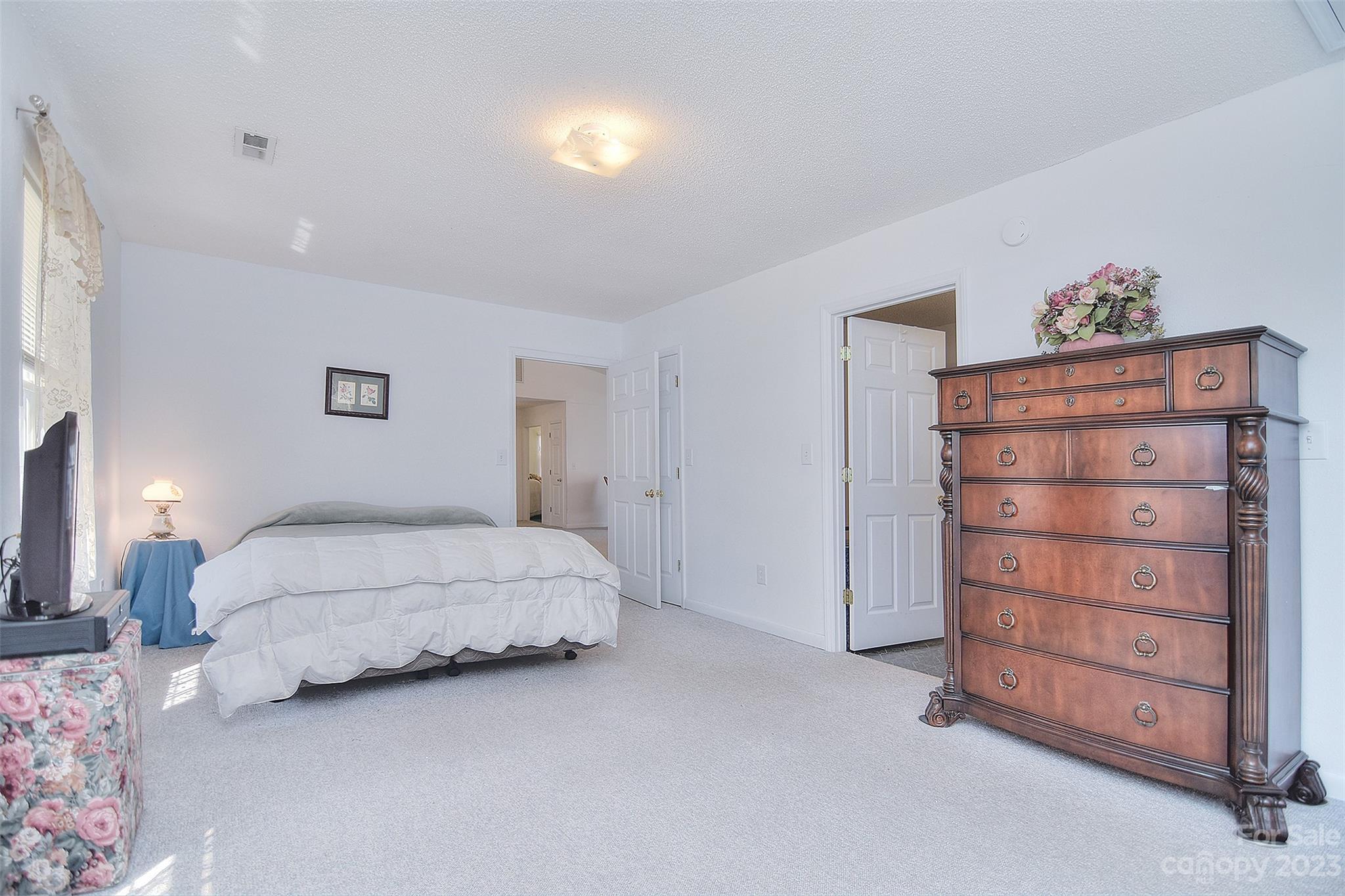8705 Simpson Road Waxhaw, NC 28173 - Photo 24 of 46 a spacious bedroom with a bed and a lamp