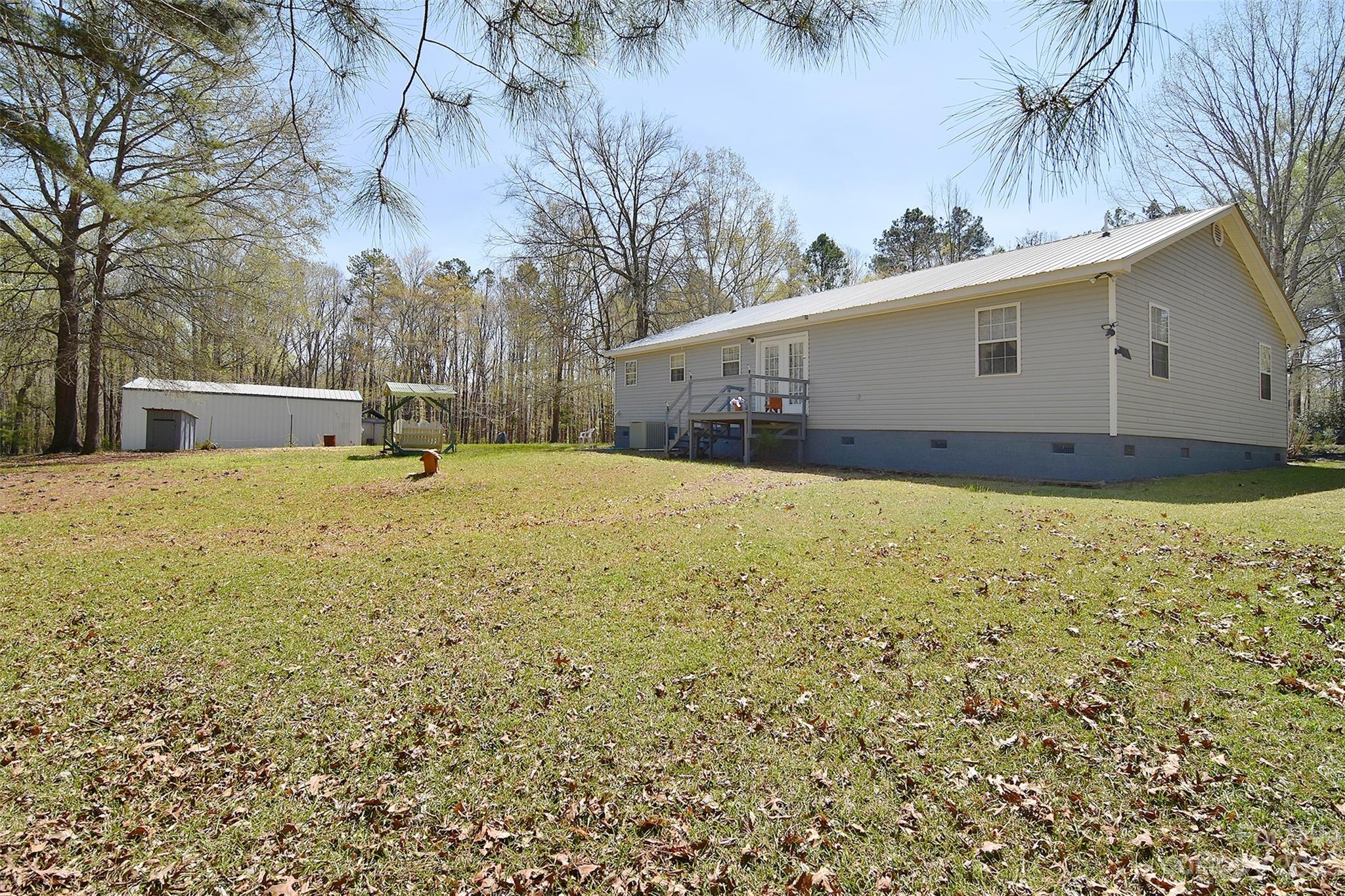 8705 Simpson Road Waxhaw, NC 28173 - Photo 37 of 46 a view of a white house with a yard