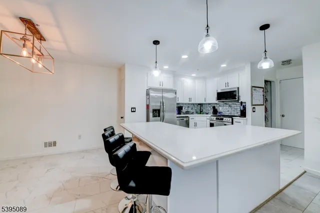 a view of kitchen with stainless steel appliances kitchen island a refrigerator sink and stove