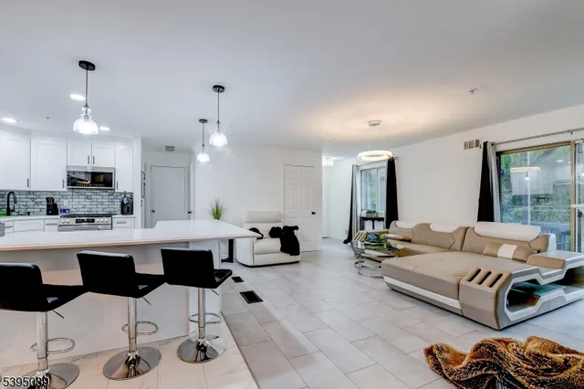 a living room with furniture and kitchen view